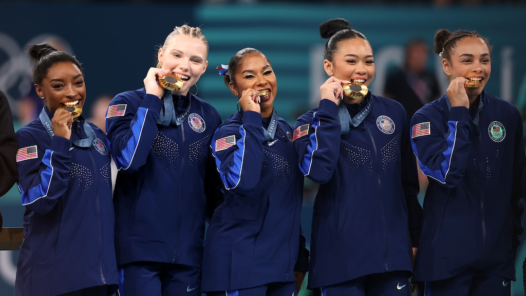 Simone Biles, Jade Carey, Jordan Chiles, Sunisa Lee, and Hezly Rivera proudly display their gold medals on the podium at the 2024 Paris Olympic Games. (Photo: Jamie Squire/Getty Images)