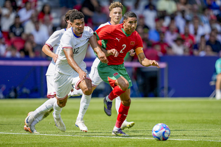 Miles Robinson of the USA and Achraf Hakimi of Morocco clash over possession during the Men's Football Quarter-final match on August 2, 2024, in Paris, France. (Getty Images).