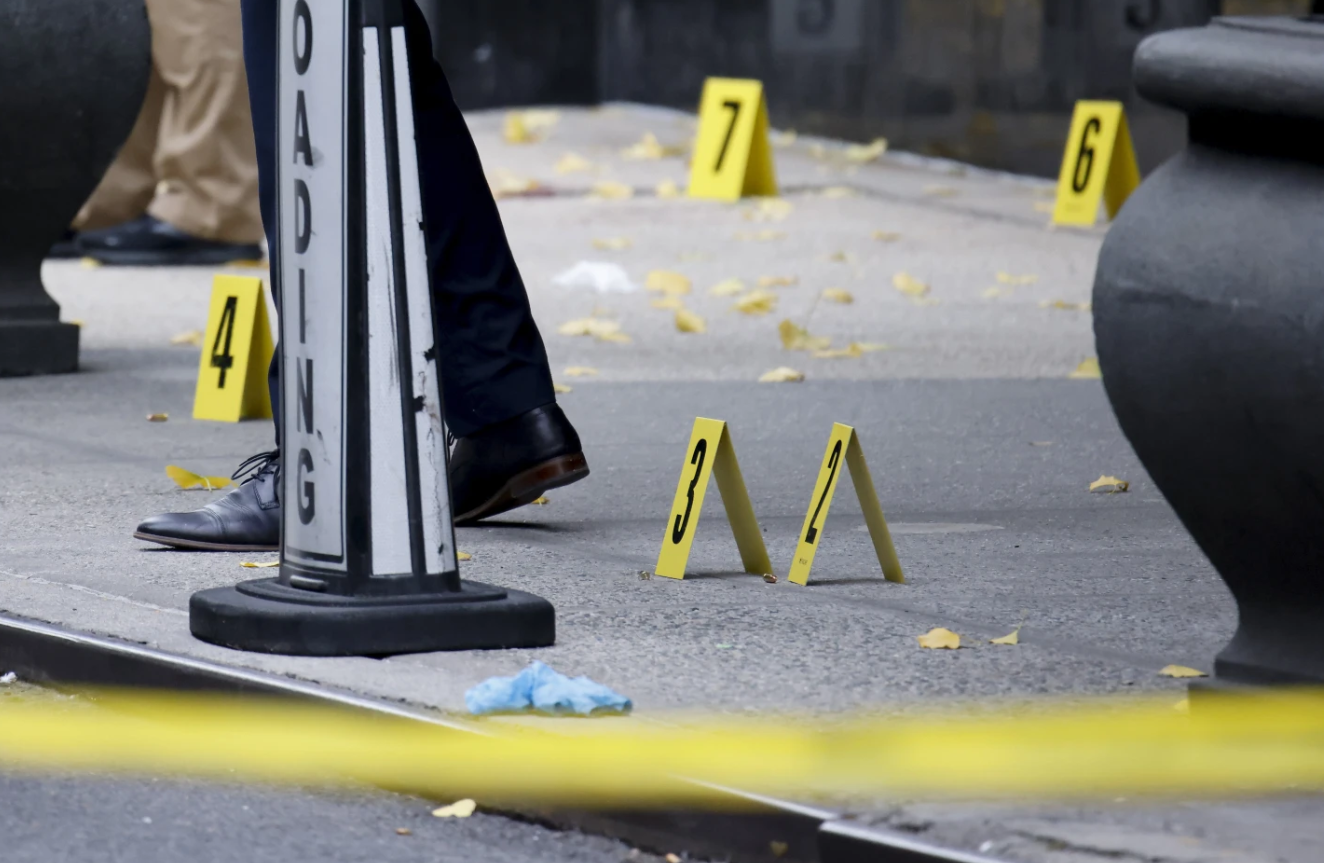 New York police investigate bullet casings on the sidewalk outside the Hilton Hotel in Midtown Manhattan, where UnitedHealthcare CEO Brian Thompson was fatally shot on Dec. 4, 2024. (AP Photo/Stefan Jeremiah)