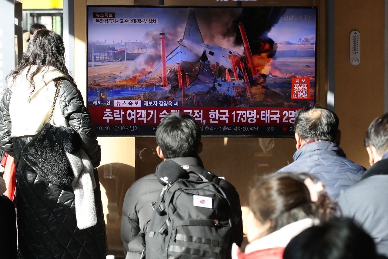 
People in Seoul, South Korea, watch a news broadcast about the plane crash on December 29. Photo by Chung Sung-Jun/Getty Images.