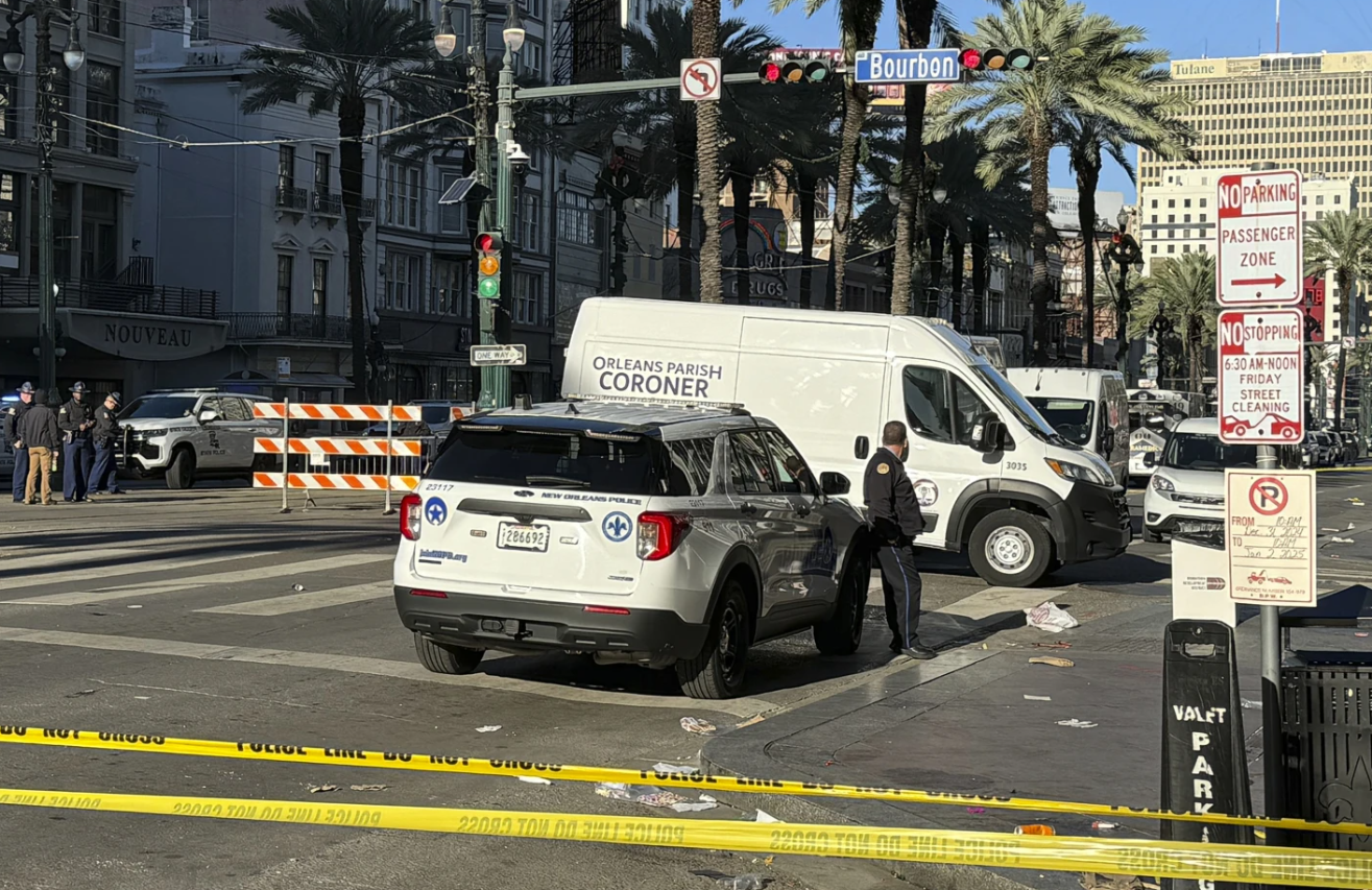 A coroner's van is stationed at Bourbon and Canal Streets after a vehicle plowed into New Year's revelers on Jan. 1, 2025. (AP Photo/Jack Brook)