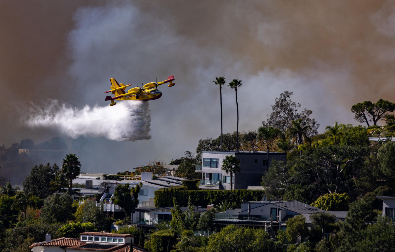 A Super Scooper Plane Drops Water on the Palisades Fire on Tuesday. (Brian van der Brug/Los Angeles Times via Getty Images)