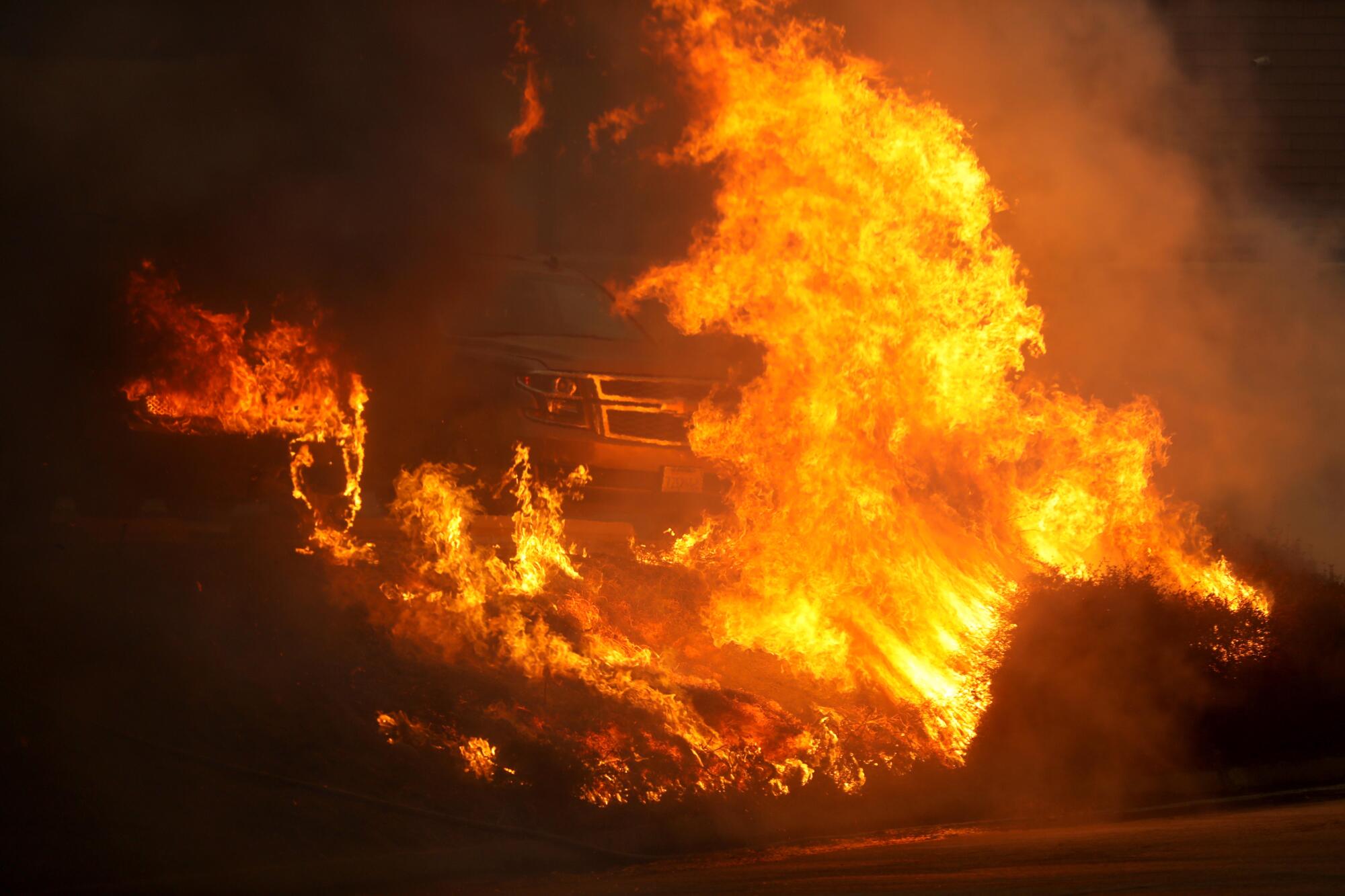 
Flames from the Palisades Fire engulf a truck along Sunset Boulevard in Pacific Palisades on Tuesday. (Photo by Genaro Molina / Los Angeles Times)