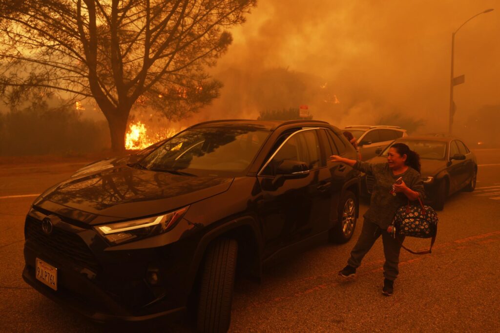 A woman breaks down in tears as the Palisades Fire rapidly engulfs parts of the Pacific Palisades neighborhood on January 7. (Photo by Etienne Laurent/Associated Press)