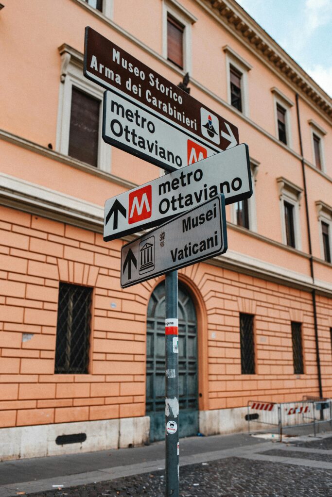 Rome, Italy White and Black Street Signs Near the Brown Concrete Building