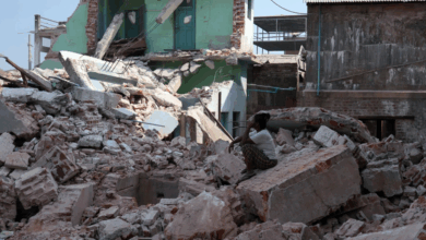 A volunteer sits atop the rubble of a collapsed building nearly one month after a powerful earthquake struck Naypyitaw, Myanmar, on April 28.