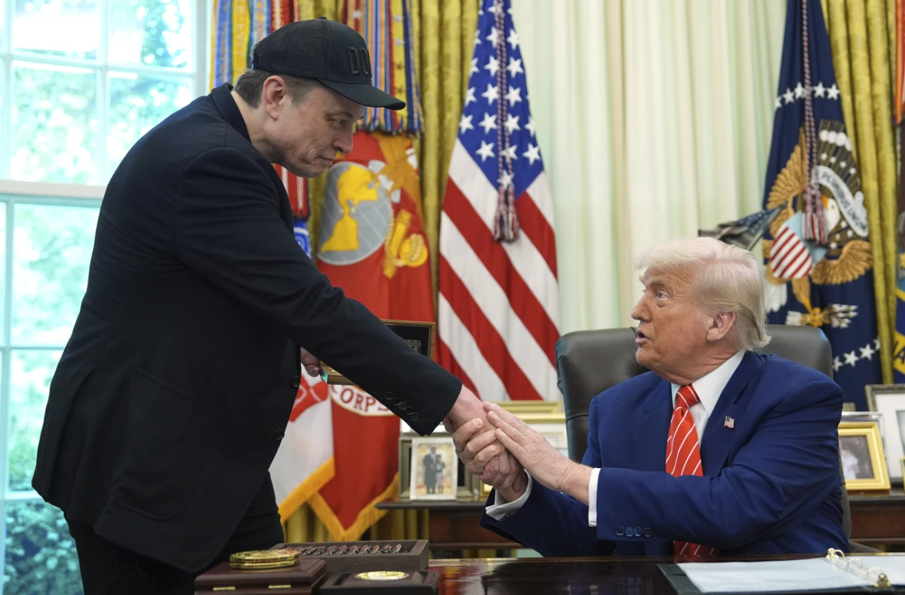 Donald Trump and Elon Musk shaking hands in the Oval Office during a press conference on May 30, 2025, in Washington, D.C.